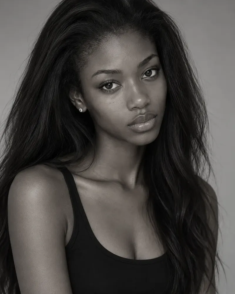 Three black and white portraits of a model with long dark hair in a black top, the kind of photos used on a comp card or in a portfolio